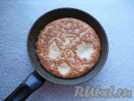 Сковороду поставить на небольшой огонь, накрыть крышкой. Готовить луковый пирог 10-12 минут, после чего перевернуть и готовить также ещё 7-10 минут под крышкой.