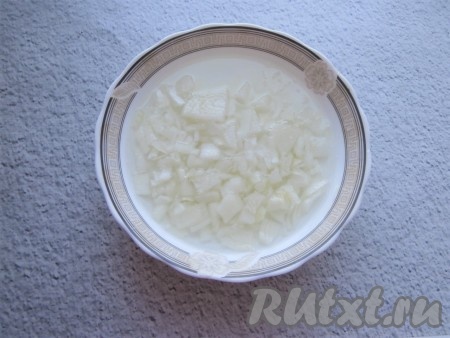 Прежде всего очищенные луковицы нужно мелко нарезать, выложить в достаточно глубокую тарелку, залить лук кипятком и оставить на 7-10 минут.