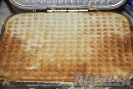 По истечении времени хорошо разогретую вафельницу смазать растительным маслом, выложить несколько столовых ложек теста, плотно закрыть и выпекать вафли до золотистого цвета. 
