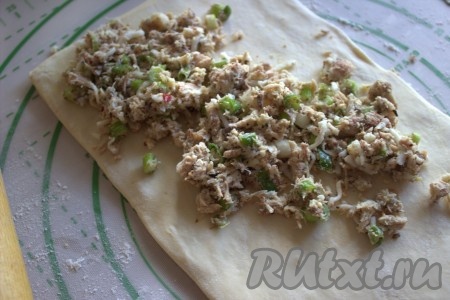 Рабочую поверхность припылить мукой, выложить размороженное слоёное тесто (я использовала уже готовые квадратные пластинки теста). Одну из частей теста раскатать в одном направлении. Перед тем как выкладывать на тесто начинку, удобнее переложить тесто на противень, застеленный пергаментом. Поверх раскатанного теста выложить подготовленную начинку, немного отступая от краёв теста.