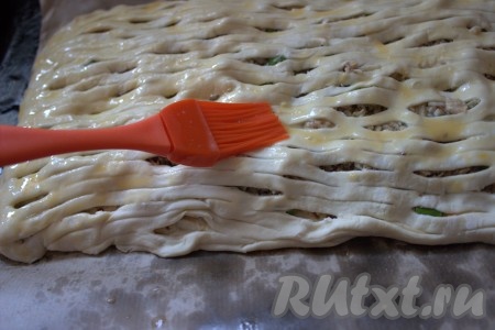 Смазать поверхность пирога слегка взбитым яйцом и, по желанию, можно присыпать чёрным кунжутом. Противень поставить в заранее разогретую духовку и выпекать слоёный пирог с рыбными консервами и яйцами минут 25-30 (до золотистой корочки) при температуре 180 градусов.