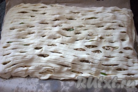 Раскатать вторую часть теста (размер получившегося пласта должен быть по размеру равен первому пласту, на который мы выкладывали начинку). Затем эту раскатанную часть теста можно нарезать, используя ролик для нарезки теста (или можно нарезать на полоски, а можно просто наколоть вилкой по всей поверхности). Подготовленной второй частью теста накрыть тесто с начинкой, хорошо скрепляя края пирога.
