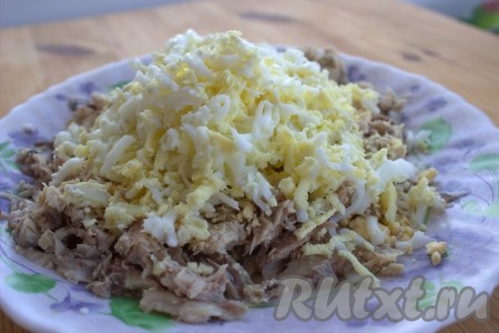 Подготовленную консервированную рыбу выложить в тарелку, добавить к ней яйца, натёртые на средней тёрке. 