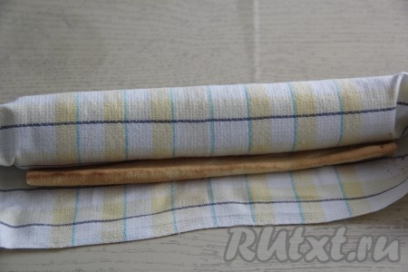 Готовый горячий бисквит переложить на сухое полотенце, снять пергамент и сразу свернуть в рулет вместе с полотенцем, оставить на 1 час. 