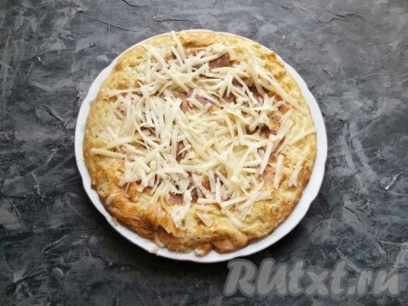 Готовить запеканку из кабачков с творогом под крышкой ещё 7-10 минут. Затем переложить со сковороды на тарелку, сразу, пока запеканочка горячая, посыпать натёртым сыром. 