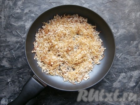 Сковороду разогреть с растительным маслом, выложить рис и вермишель, обжарить их на сильном огне, постоянно помешивая, до румяности вермишели (в течение 3-4 минут).