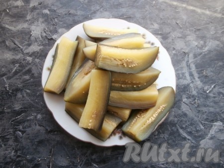 Выложить баклажаны в кипящую воду, дать закипеть, а затем отварить в течение 4-5 минут, вынуть и остудить.