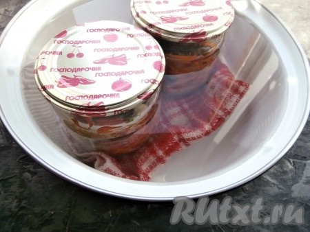 Банки поставить в кастрюлю, на дно которой разместить полотенце (или любую тряпочку), накрыть прокипячёнными крышками. Влить горячую воду, чтобы она была по "плечики" банок. Поместить кастрюлю на огонь, довести воду в кастрюле на среднем огне до кипения, а затем, уменьшив огонь, стерилизовать салат 15 минут.