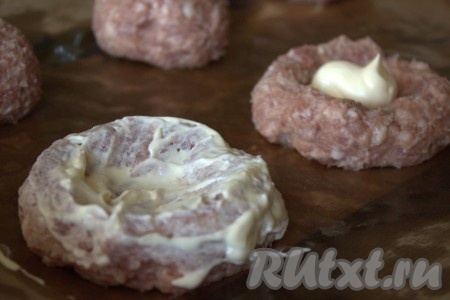 Затем каждый шарик из мясного фарша приплюснуть и сделать небольшое углубление в центре (сделав так называемую "ватрушку"). Каждую мясную ватрушку смазать майонезом.