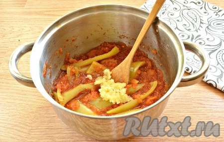 Когда содержимое кастрюли закипит, уменьшаем огонь и варим лечо из помидоров и перца, иногда помешивая, минут 30-40 минут. Затем добавляем измельчённые с помощью пресса зубчики чеснока, перемешиваем и провариваем ещё 5 минут.