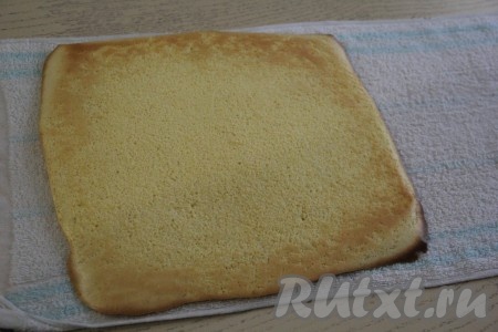 Перевернуть бисквит на влажное полотенце и снять пергамент.