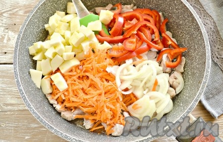 Очищаем морковку и лук. С кабачка срезаем кожуру и удаляем семена, а затем нарезаем кубиками. Из болгарского перца удаляем семечки с плодоножкой, нарезаем его полосками. Добавляем к обжаренной свинине натёртую на тёрке морковь, нарезанный тонкими полукольцами лук, а также подготовленные болгарский перец и кабачки, сразу перемешиваем.