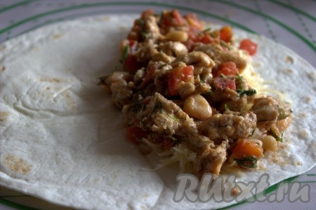 Поверх сыра выложить 1-2 столовые ложки куриного мяса, смешанного с помидорами и фасолью.