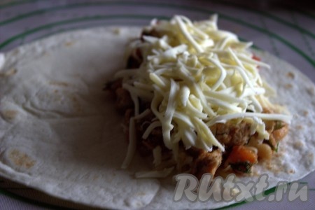 На смесь курицы и овощей выложить ещё немного натёртого сыра.