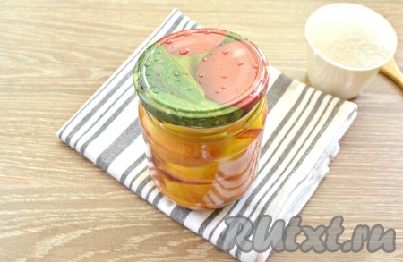 Банку с нектаринами до самого верха залить горячей водой, которую вскипятили в кастрюле, накрыть крышкой и оставить на 15 минут.