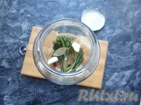 На дно хорошо вымытой банки выложить укроп, горошины душистого перца, очищенные зубчики чеснока, лавровые листики, горошины чёрного перца.