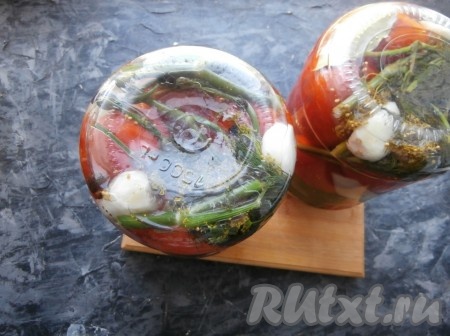 Залить помидоры кипятком так, чтобы вода немного выливалась через край и сразу банку закрутить крышкой, перевернуть. Банку нужно покрутить, чтобы сахар внутри растворился.