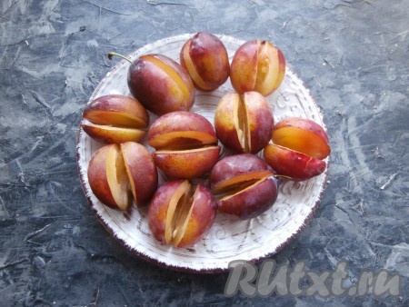 Разрезать сливы с одной стороны и вынуть косточки. Разрез делаем не до конца, чтобы была возможность вынуть косточку и оставить сливу целой.