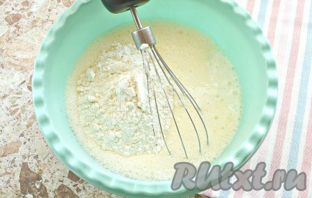 Когда яичная смесь станет однородной, вливаем в неё 200 мл обезжиренного кефира комнатной температуры и всыпаем просеянную пшеничную муку.