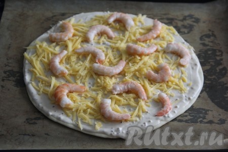 Затем разложить по пицце креветки.