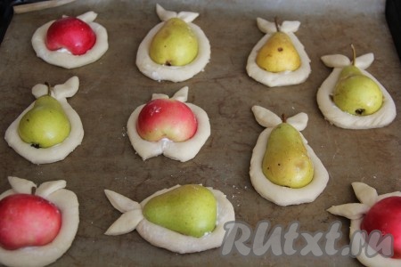 Переложить слойки с грушами и яблоками на противень, застеленный пергаментом. Из остатков слоёного дрожжевого теста вырезать листики и прикрепить по 2 листочка к каждой слоечке. Оставить слойки на 20 минут для расстойки.