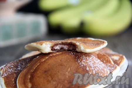 Пакейки, обжаренные с двух сторон, переложить на тарелку. Постепенно пожарить все панкейки, складывая их горочкой на тарелку. Они получаются очень аппетитными, а шоколадная начинка делает их вкус особенно интересным.