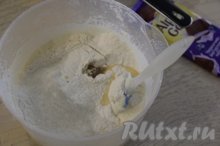 Во взбитую яичную массу влить растительное масло и кефир, смешанный с содой, всыпать муку.