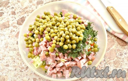 Зелёный горошек сначала откидываем на сито, чтобы убрать лишнюю жидкость, а потом перекладываем в миску с овощами и ветчиной. Сюда же добавляем и промытый, мелко нарезанный укроп.