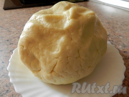 Когда тесто начнёт собираться в шар, добавляя понемногу муку, продолжать замешивать его руками. Творожное тесто для рогаликов должно получиться очень мягким, эластичным, не липнущим к рукам. Как только добились нужной консистенции теста, значит больше не нужно добавлять муку. Скатать тесто в шар, завернуть в плёнку и убрать в холодильник на 30-40 минут.