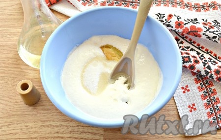 Затем в смесь сметаны и соды добавляем 2 столовые ложки растительного масла, сахар, соль и яйцо.