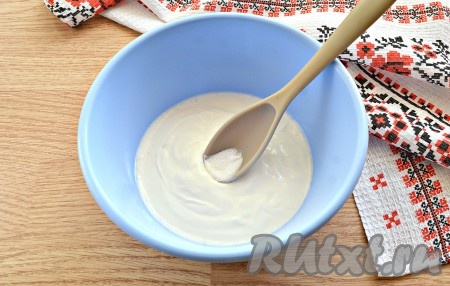 Сметану комнатной температуры выкладываем в миску, добавляем соду, перемешиваем ложкой и оставляем на 5 минут. Благодаря кислоте, содержащийся в сметане, сода «активизируется» и на поверхности сметаны образуются пузырьки.