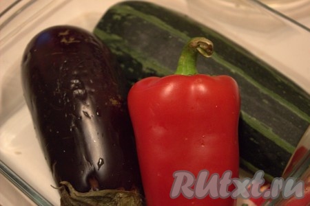 Болгарский перец, кабачок, баклажан и помидоры вымыть, обсушить бумажным полотенцем и проколоть овощи зубочисткой (или вилкой) в нескольких местах. Луковицу вымыть, обсушить, от шелухи очищать не нужно. У меня был крупный кабачок, поэтому я разрезала его вдоль, семечки удалила, кожуру перед запеканием срезать не стала. Подготовленный кабачок весил 200 грамм. Овощи можно запекать в одной большой форме для запекания (или на противне), я же решила выложить их в 2 формы для запекания. Баклажан, перец и кабачок я выложила в одну форму для запекания.