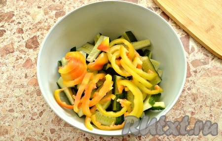 Подготовленный перец нарезаем полукольцами, выкладываем к огурчикам.