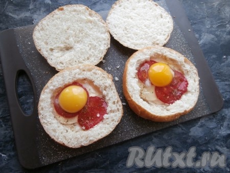 Аккуратно разбить по одному яйцу в каждую булочку, не повредив желток.