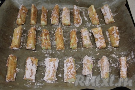 На противень, застеленный пергаментом (или тефлоновым ковриком), выложить запанированные брусочки кабачков.