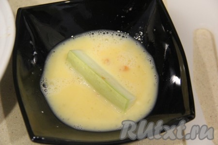 Обмакнуть брусочки кабачка со всех сторон в яйцо.