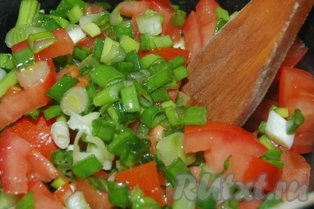 Выложить нарезанные помидоры и зелёный лук на сковороду, обжарить их, всё время помешивая, на среднем огне. Желательно не добавлять никакой жидкости, помидоры и лук дадут сок, но если всё же помидоры не очень сочные, можете добавить несколько столовых ложек рыбного бульона из кастрюли.
