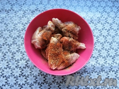 Куриные крылья вымыть, разрезать на 2 части каждое крылышко, удалить кончики. Посолить крылья, поперчить, посыпать специями и паприкой, перемешать.