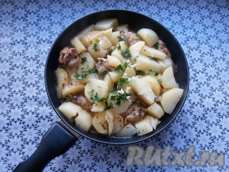 Влить горячую воду, накрыть сковороду крышкой и на медленном огне готовить блюдо 30-40 минут. В конце добавить мелко нарезанный чеснок и измельчённую зелень.