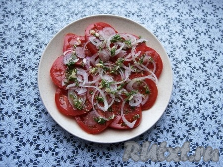 Сверху разместить очищенный репчатый лук, нарезанный тоненькими кольцами (или полукольцами). Снова полить заправкой. Помидоры с луком можно выкладывать, чередуя с заправкой, в несколько слоёв.