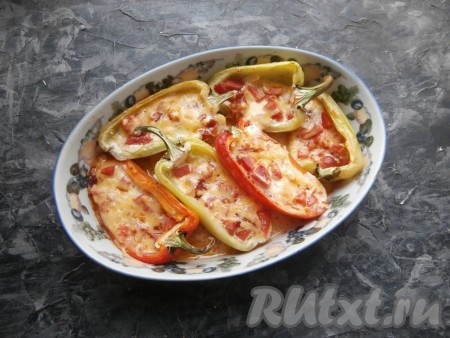 Запекать половинки перца с начинкой из помидоров и сыра в разогретой духовке 25-35 минут при температуре 180 градусов.