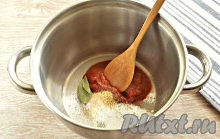 В кастрюлю кладём томатную пасту. Всыпаем сахар, соль, добавляем лавровый лист, чёрный молотый перец, по желанию, можно положить гранулированный чеснок.