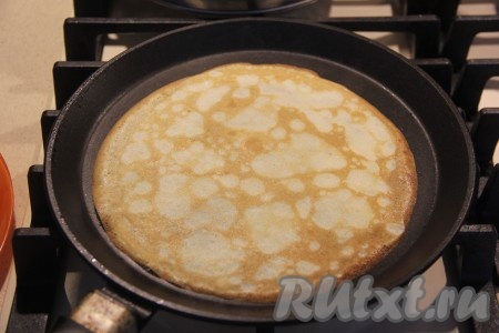 Когда блин зарумянится снизу, перевернуть его и жарить до золотистости с другой стороны. Блинчики получаются тонкими, но переворачиваются легко. Готовый блинчик переложить на тарелку. Постепенно пожарить все ажурные блины.