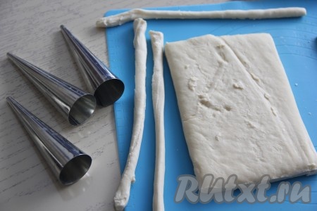 Размороженное тесто нарезать на длинные полоски шириной 1 см. Для формирования трубочек я использовала металлические конусы (их можно приобрести в магазинах).

