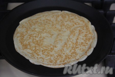 Выпекать блинчик с двух сторон на среднем огне до золотистого цвета, переложить на тарелку. После выпечки каждого блина желательно перемешивать тесто, чтобы оно не застаивалось. Постепенно пожарить все блинчики.