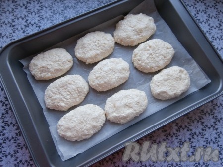 Влажными руками сформировать сырники любой формы, выложить на противень, застеленный пергаментной бумагой и смазанный растительным маслом. В процессе запекания сырники немного увеличатся в объёме, поэтому лучше их выкладывать на некотором расстоянии друг от друга.