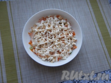 Одно яйцо порубить ножом и выложить сверху моркови, нанести немного майонеза.