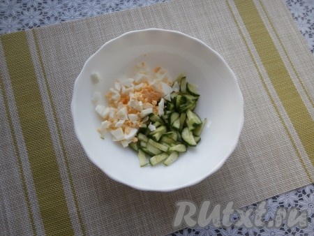 Отварить яйца в течение 8-10 минут с начала кипения воды, затем полностью остудить их, залив холодной водой, и очистить. Свежий огурец нарезать тонкими полукружочками (или брусочками), выложить в глубокую тарелку (или в миску), добавить рубленое ножом варёное яйцо.