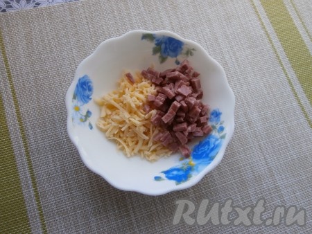 Сыр натереть на средней (или мелкой) тёрке. 1/3 части отложить. К оставшимся 2/3 натёртого сыра добавить мелко нарезанную колбасу.