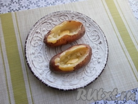 Поместить тарелку с картошкой в микроволновку, накрыть специальной крышкой с открытым клапаном для выхода пара и готовить 10 минут при мощности 750 Ватт. За это время картофель полностью будет готов! Готовность клубней можно проверить, проколов их вилкой (если вилка с лёгкостью входит в картошину, значит она готова, если же нет - картошку нужно будет снова поставить в микроволновку и готовить ещё 1-2 минуты). Полностью готовую картошку достать из микроволновки, дать немного остыть, затем сделать разрезы на клубнях и вынуть половину мякоти. Внутрь картошки поместить по небольшому кусочку сливочного масла, немного посолить.